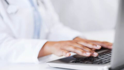 hands typing on laptop keyboard