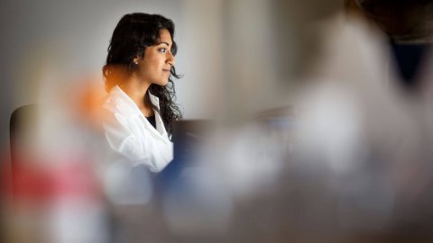 Researcher wearing white coat in lab