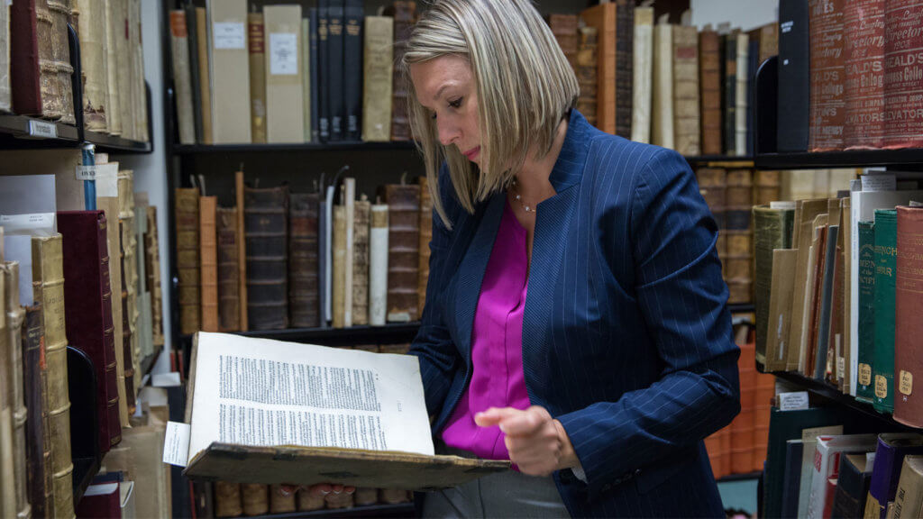 Polina Ilieva, Head Archivist reviewing a rare book from the Archives & Special Collections.