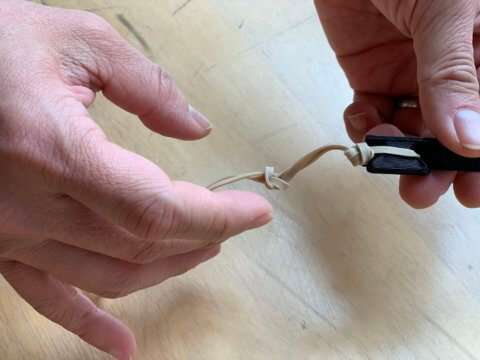 Staff showing connecting rubber bands to face shield frame.
