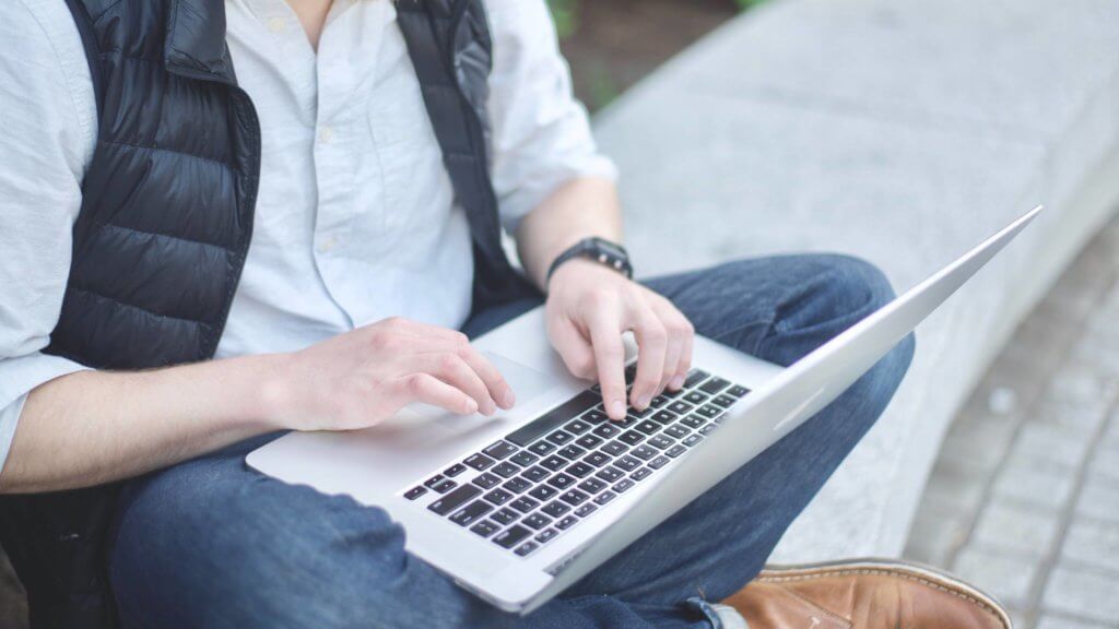 man using computer outside