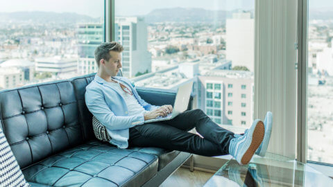 man with city view working on laptop