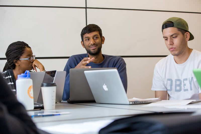 Students with laptops having discussion
