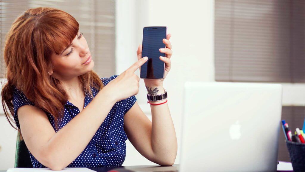 woman pointing to mobile device