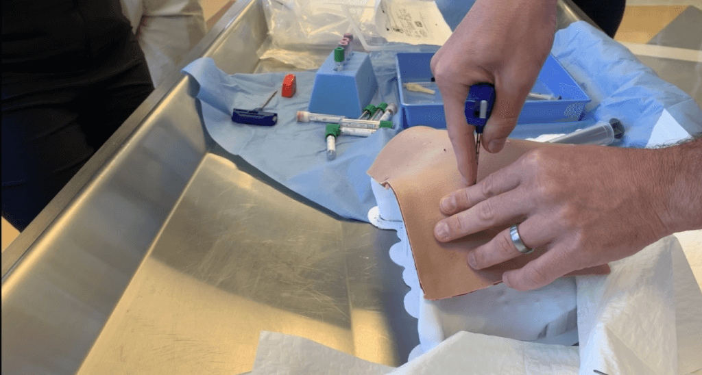 Fellow performing bone marrow aspiration with 3D printed model