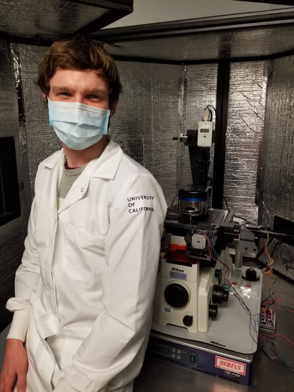 Connor next to lab equipment