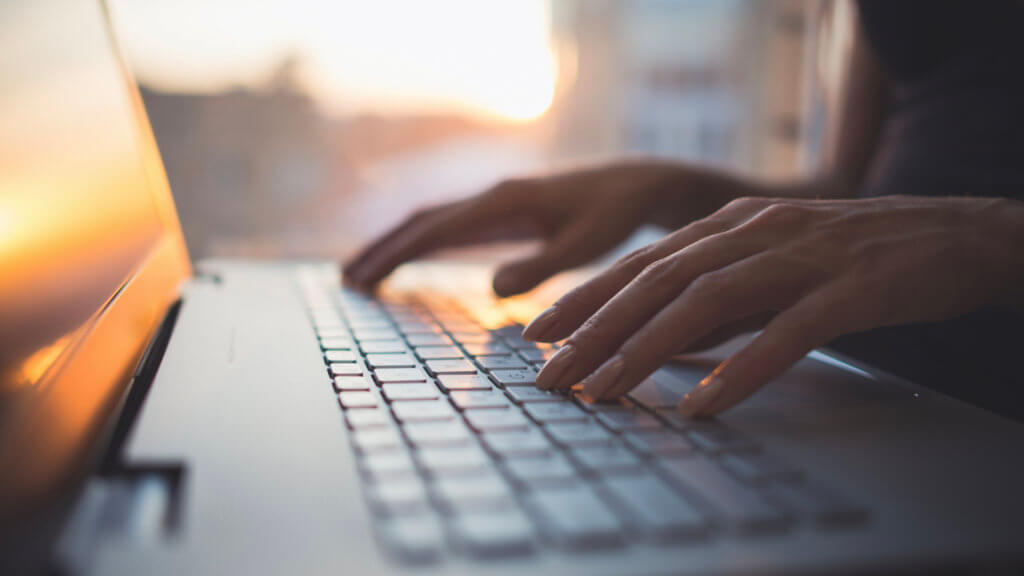 Person typing on laptop keyboard