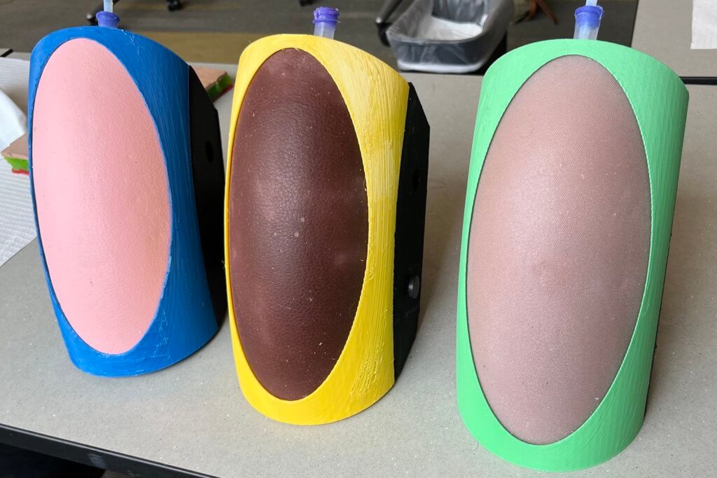 Colorful array of lumbar puncture/intrathecal therapy simulation models with 3D printed and silicone components.