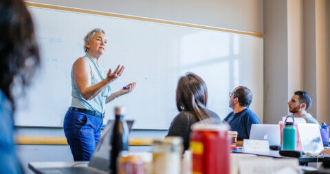 UCSF educator Maureen McGrath, RN, MS, PNP teaches a diabetes simulation class in front of a whiteboard.