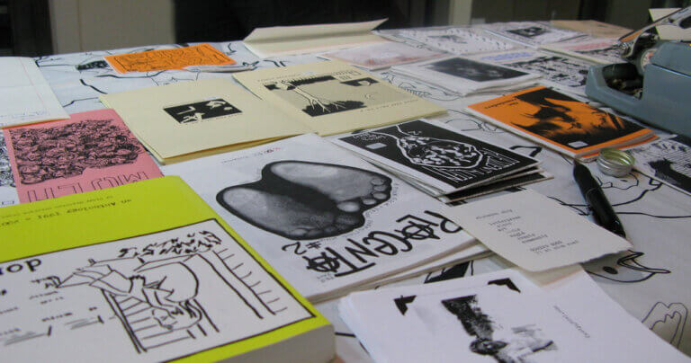 Zines and books on a table.