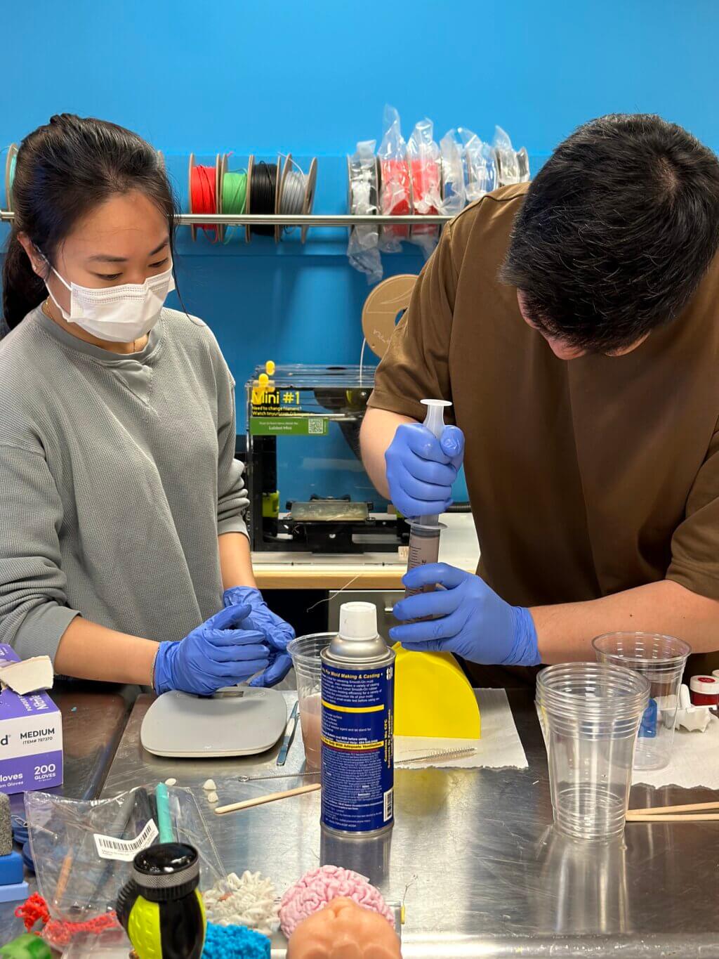 Two people casting the 3D printed mold with silicone in the Makers Lab