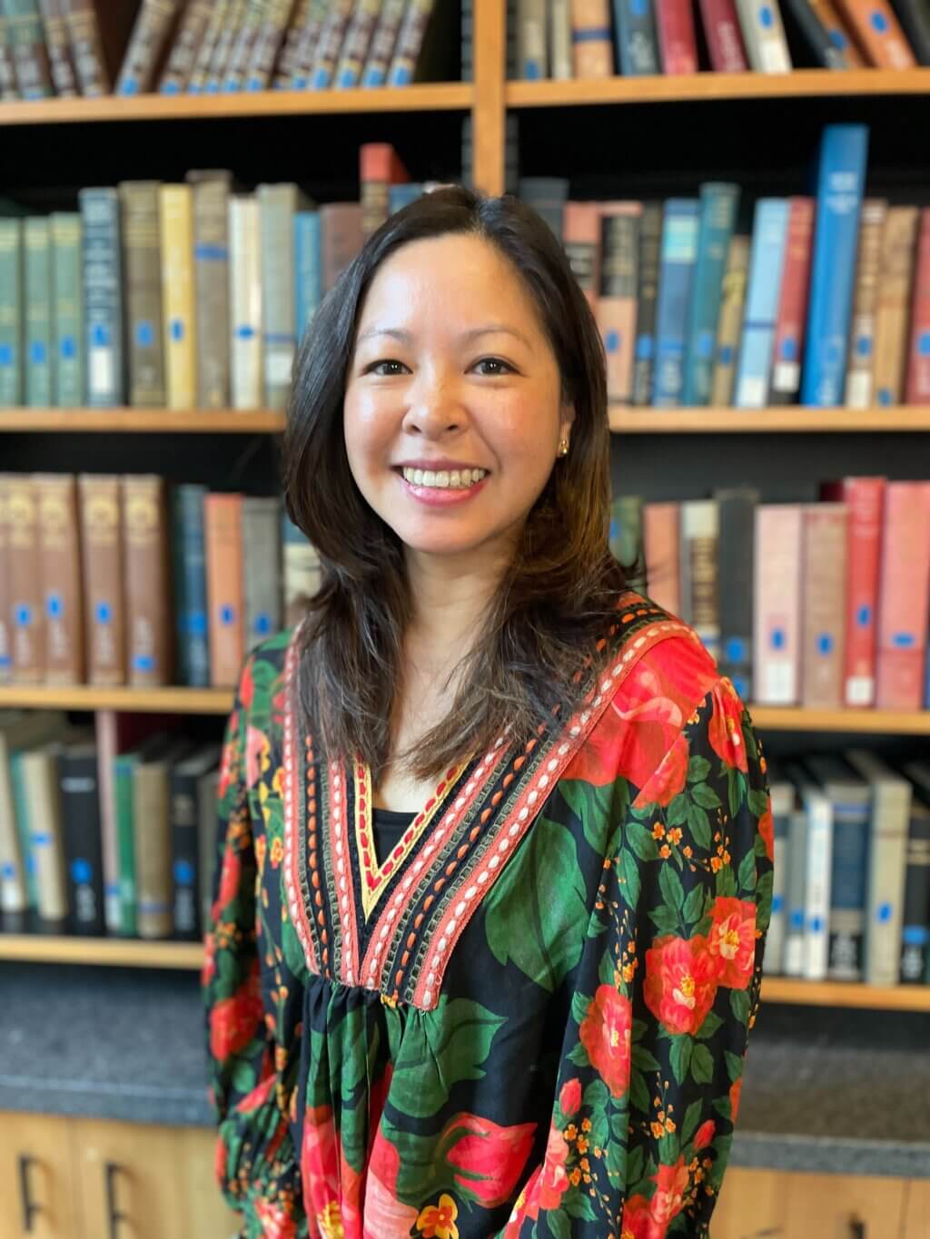Lisa Nguyen standing in front of a bookshelf