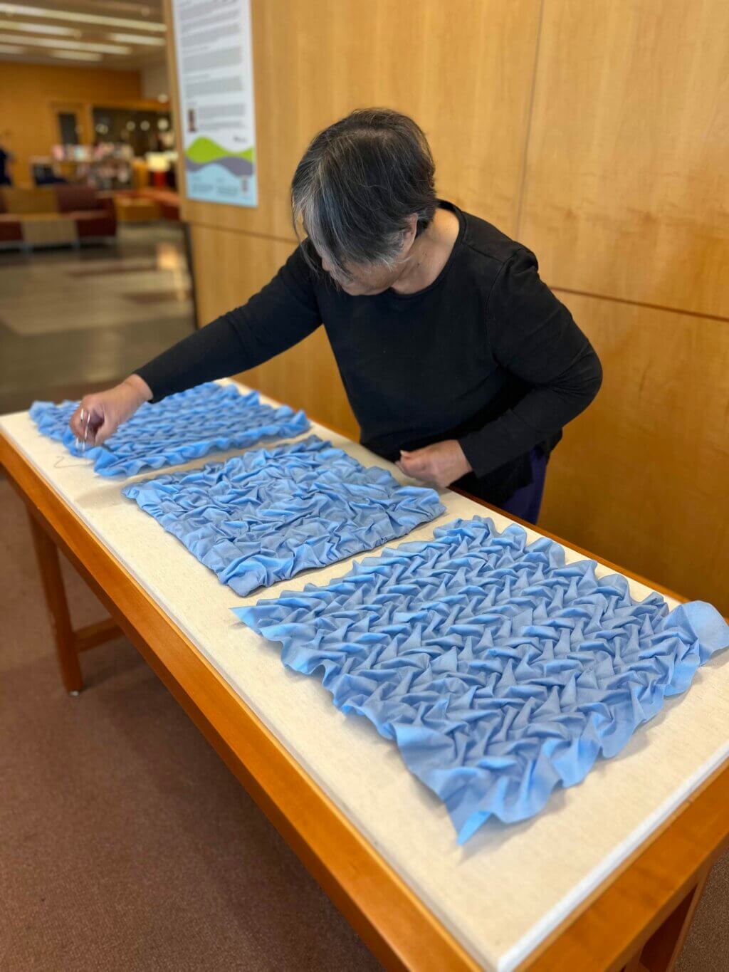 Ruth installing the Suture triptych in the UCSF Library,
