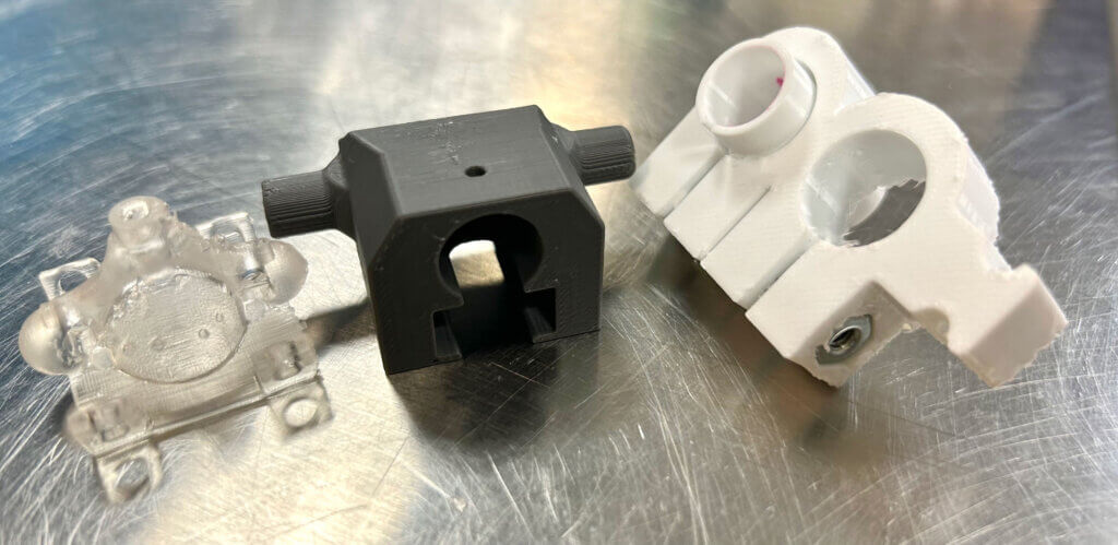 3D printed copies of stereotaxic nosecone and accessories in clear, black and white plastics.