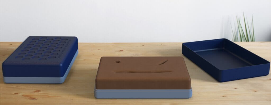 Digital render of original full-silicone design with three wound variations, sitting on wooden table