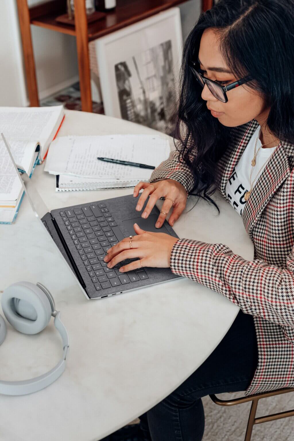 woman working on a laptop at her dining room table