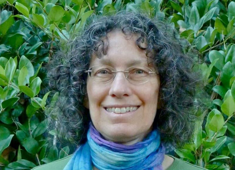 Headshot of Rene Hoffinger with green plants in the background.