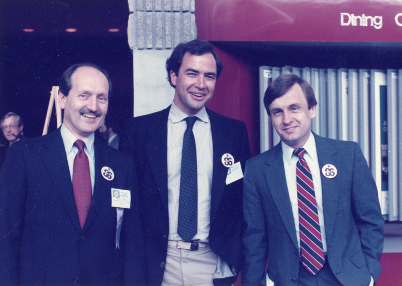 Paul Volberding, MD, standing between two men, all three are wearing suits, ties, and Ward 86 buttons.